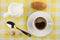 Coffee cup, milk jug, croissant, sugar and spoon on napkin