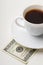 Coffee cup and one hundred U.S. dollars