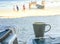 Coffee cup and personal belongings on the beach table.