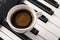 Coffee cup on piano keyboard