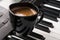 Coffee cup on piano keyboard