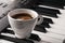 Coffee cup on piano keyboard