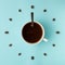 Coffee cup and roasted beans arranged as clock face on blue background, top view. Coffee time symbol. Interesting idea energy and