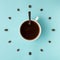 Coffee cup and roasted beans arranged as clock face on blue background, top view. Coffee time symbol. Interesting idea energy and