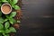 Coffee cup with roasted coffee beans, ground coffee powder and fresh mint leaves on wooden background. Top view, flatlay, copy