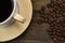 Coffee cup and roasted coffee beans on wooden background