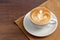 Coffee cup of rosetta latte art place on napkin on wooden background