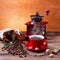 Coffee cup and saucer, coffee grinder, coffee beans in sack and spilled on wooden table.