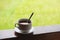 Coffee cup with saucer, on wood panel with defocus green grass lawn background