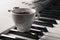 Coffee cup with smoke on piano keyboard