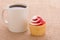 Coffee cup with a strawberry flavored cupcake