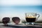 Coffee cup and Sunglasses on wood table with beach chairs & sand