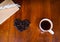 Coffee cup on the table and black rose coffeebean. heart shape bean on wooden table. afternoon refreshing drink for coffee lover.