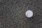 Coffee cup with a white cap on a gray asphalt top view. rough surface texture