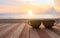 Coffee cup on wood table at sunset or sunrise beach