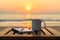 Coffee cup on wood table at sunset or sunrise beach