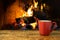 Coffee cup on wooden table over fireplace.