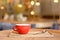 Coffee cup on wooden tray in modern cafe interior with blurred background.