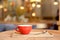 Coffee cup on wooden tray in modern cafe interior with blurred background.