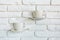Coffee cups as lamp decorations on a white brick wall in modern loft cafe
