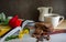 Coffee cups and chocolate chip baked cookies with red roses on books.