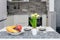 Coffee cups and fruits for breakfast. Morning table with espresso, fruits and flowers on a white wooden table in the kitchen