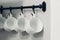 Coffee cups hanging on hooks of kitchen wall