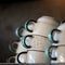 Coffee cups pyramid. Clean clay cups dry on table. Close up shot, side view. Soft focus. Copy space