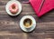 Coffee, donut and pink notepad on wooden background