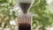 Coffee Drip Concept. Hot Water Drops from a Dripper to a Glass. Making Hot Coffee Drink in the Backyard. Zen and Cozy Living