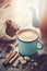 Coffee in enameled cup , sugar cubes, sack of coffee beans and spices.