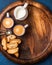 Coffee espresso, cookies and milk on wooden serving round board