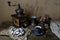 Coffee in a gray cup and saucer on a wooden table, walnuts, vintage manual coffee grinder, two donuts with glaze, coffee time