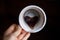 coffee grounds in shape of heart on bottom of cup. Fortune teller hand hold cup