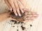 Coffee hand scrub with ground coffee on wooden background