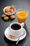 Coffee, italian cookies and orange juice on black background