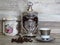 Coffee jars and a cup of coffee on bleached oak wooden shelf porcelain and glass silver vintage sterling.