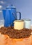 Coffee kettle cups and beans with blue background