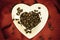 Coffee klatsch java concept. Heart shaped cup filled with roasted coffee beans