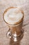 Coffee latte with closeup froth on rustic