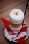 Coffee latte in glass Cup with handle,high foam.Standing on a red napkin