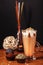 Coffee latte macchiato with mint syrup and whipped cream, in high transparent glasses with cakes, on a dark background