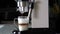 The coffee maker prepares the morning latte make-up in a glass mug. Pours espresso into a mug with milk. Close-up. Preparing morni