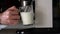 The coffee maker prepares the morning latte make-up in a glass mug. Pours espresso into a mug with milk. Close-up. Preparing morni