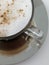 Coffee with milk and cinnamon on a silver plate. Mirror reflection.