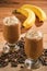 Coffee milk cocktails with banana on wooden background.
