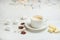 Coffee with milk, latte with cinnamon sticks and anise stars with white chocolate and marshmallow, on a light white background,