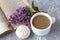 Coffee with milk and marshmallows. Reading a book in the garden with a cup of coffee. Romantic still life with lilac flowers