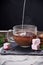 Coffee with milk preparation in glass cup with marshmallow