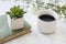 Coffee mug and book with plants on table